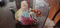 Porcelain teapot shaped as an old man and young boy, colorful with intricate design