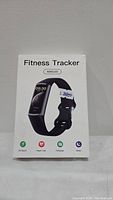 Boxed white package labeled 'Fitness Tracker AMOLED' with image of fitness tracker, highlighting 25 sport modes, heart rate, message, and sleep functions.