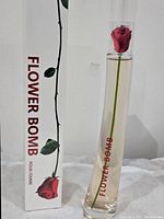 Photo showing the full bottle and box of Flowerbomb perfume with a red rose image and branding.
