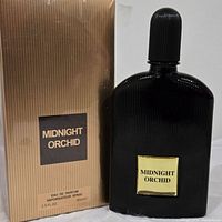Photo of boxed and unboxed Midnight Orchid Eau de Parfum perfume bottle, black bottle with gold label and matching gold striped box.