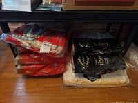 Image showing multiple stacks of Texmade flannelette linens in original packaging, including red and black packagings as well as cream-colored linens.