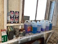 Wide shot of shelf with multiple fluid containers, metal cans, steel wool box, and jars with hardware