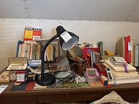 Wide view of desktop showing lamps, books, pen sets, clocks and other items