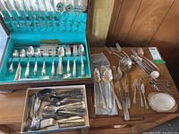 Full view of wooden Tudor Plate cutlery case open on table alongside loose utensils and a separate box.