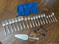 Full assortment of forks, spoons, ice cream fork, pie lifter and blue fabric roll