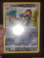 Photo of holographic Copperajah Pokemon card showing card details and holographic effect.