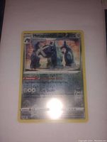 Photo showing Metagross reverse holo Pokemon card from the front with some glare on the card surface.