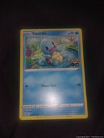 Photo of the Squirtle Pokemon trading card showing front artwork and attack details.