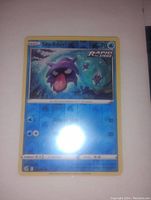 Front view of the Shellder Rapid Strike Reverse Holo Pokemon card showing the holographic effect and card details.