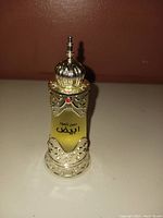 Front view of Afnan White Oud perfume bottle showing ornate gold design and crown cap