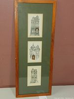 Full view of the set of three framed ink and watercolor artworks depicting Toronto landmark buildings by David Crighton. The artworks are vertically arranged in a single wooden frame with green matte board.