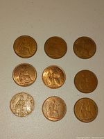 Top side showing nine British large pennies featuring Britannia seated design in used condition