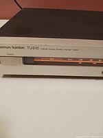 Close-up of front left side showing brand, model (TU610), and illuminated signal indicator including AM/FM and stereo light indicators.