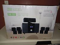 Box of Dulmen Belzdorf DB-707 home theater system showing branding and image of the components including the subwoofer and speakers.