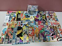 Top view of comics laid out face up showing various vintage DC and Marvel comic covers; Spider-Man mug box placed on top.