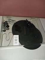 Assorted record player parts including belts, small components, and a Sony clear plastic cover