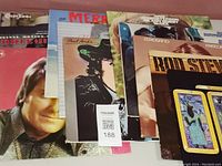 Photo showing a stack of used vinyl records including Paul Anka, The Merle Haggard, and partially visible covers.