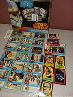 Front view of the Disney-branded Star Wars collectible cards and stickers scattered in front of the box showing multiple character portraits and scenes.