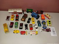 Full overview of Tonka, Hot Wheels, Majorette toy car lot with 23 toy vehicles including trucks, cars, train locomotive, and a race boat.
