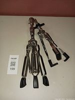 Folded Westbury snare drum stand showing metal arms, rubber grips, and tripod legs feet.