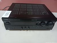 Front view of Yamaha RX-V495 showing control knobs, power button, and input selection buttons.