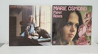 Photo showing Carole King's "Tapestry" album cover featuring Carole King sitting barefoot with a cat, and Marie Osmond's "Paper Roses" album featuring a close-up of Marie Osmond with roses on cover.