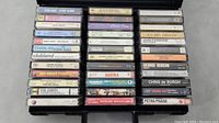 Photo showing a case full of 36 assorted cassette tapes with visible artist titles and album names.