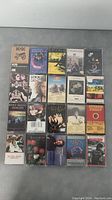 Photo showing all 20 cassette tapes laid out on a flat surface in 4 rows of 5 covering various rock and pop artists.