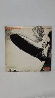 Front cover of Led Zeppelin LP album showing the iconic Hindenburg airship disaster image and Led Zeppelin text in upper left corner.