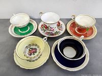 Top view showing five teacups each placed on their matching saucers in different colors and designs