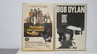 Two small movie posters displayed side by side, The Beatles Yellow Submarine on the left and Bob Dylan Don't Look Back on the right. Both posters are protected inside plastic sleeves showing minor scratches.