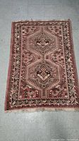 Full view of the vintage handmade rug showing overall geometric pattern and condition