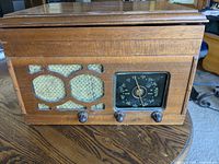 Front view of the wooden cabinet showing the radio speaker grille, tuning dial, and control knobs
