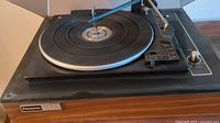 Panasonic stereophonic turntable showing wooden base and black playing surface with tonearm extended, branding plate visible.