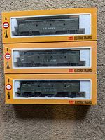Three new Cox HO scale U.S. Army electric locomotives in original boxes stacked vertically, showing front side.