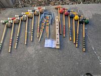 Full view of two complete croquet sets with mallets, balls, stakes, stand parts, and instruction sheet