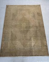 Full view of the antique washed Persian hand knotted rug laid flat showing the overall faded colors and central medallion design.