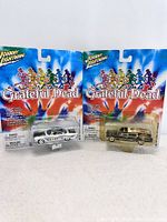 Front view showing two Johnny Lightning Grateful Dead cars in sealed blister packaging with visible colorful tie-dye background and dancing bears logo.