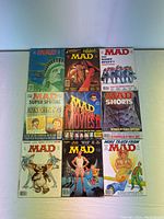 Photo of nine individual Mad Magazine issues showing the cover artwork and titles.