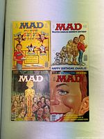 Front covers of four different Mad Magazine issues showing various colorful illustrations and caricatures.