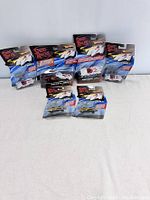 Six Hot Wheels Speed Racer cars displayed in original packaging on white surface, front view showing car models and boxes.