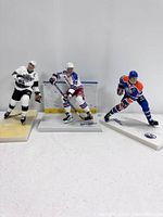 Photo showing all three Wayne Gretzky hockey action figures positioned side by side on display bases.