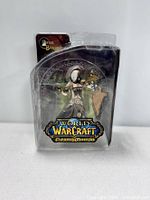 Front view of the Sister Benedron action figure in blister package, showing character and World of Warcraft logo.