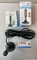 Digital HDTV antenna with 360-degree reception and strong magnetic base, shown with its original box and user manual.