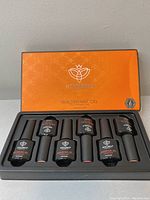 Closed orange box containing 6 bottles of Modelones Builder Nail Gel with black handles and the brand logo on the box lid.