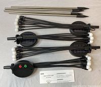 Four solar garden lights laid out flat showing solar panel housings, control panels, metal stakes, and wired LED bulbs with white orbs.