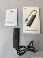 Top view showing Acer USB hub, user manual, and product box on flat surface