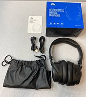 Photo of all lot contents showing headphones, cables, manual, carry pouch, and box