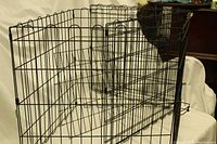 Side view of black collapsible wire pet crate showing its structure and latch.