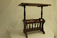 Photo of the vintage wooden magazine table showing overall structure, flat tabletop, turned legs, and built-in magazine rack with spindle dividers.